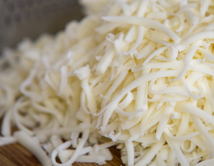 White shredded plant-based cheese in a bowl, representing dairy-free cheese alternatives