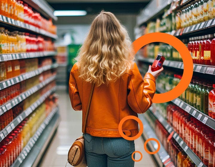 Shopper in a grocery store beverage aisle holding a drink, highlighting functional beverage innovation