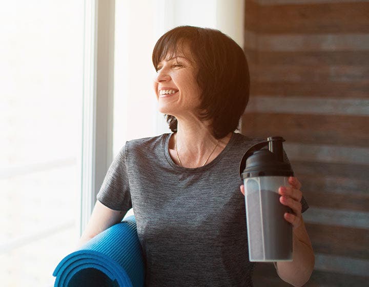 Woman smiling holding a protein shake